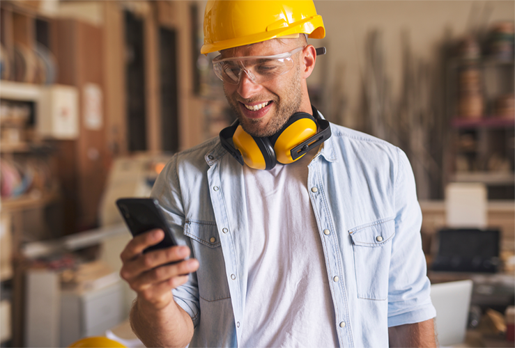 A man in construction field collecting data on phone with GoCanvas.