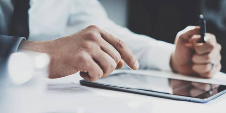 man signing waiver form on tablet device